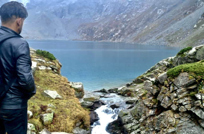 Furqan looking out over an alpine lake